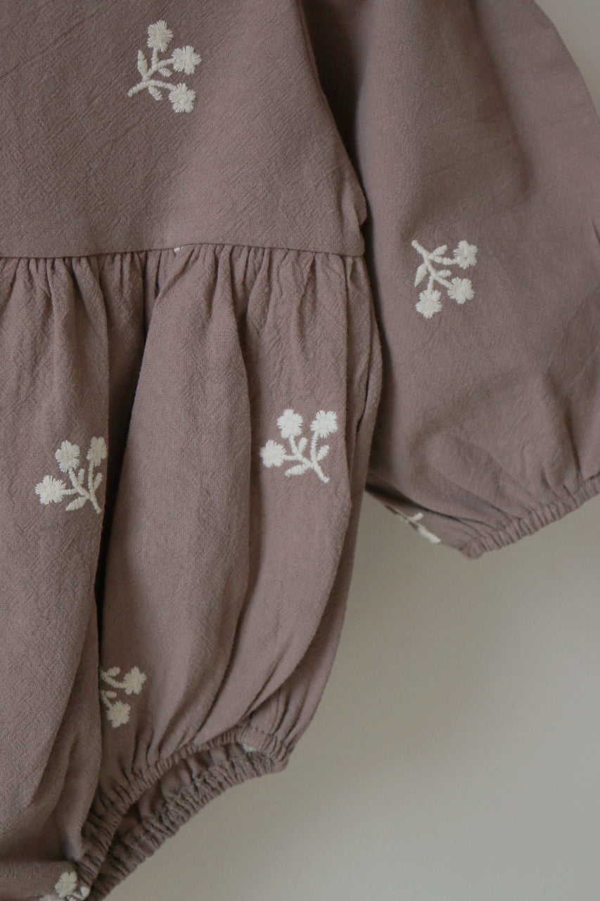 Grey children's outfit with ivory floral patterns on a neutral background