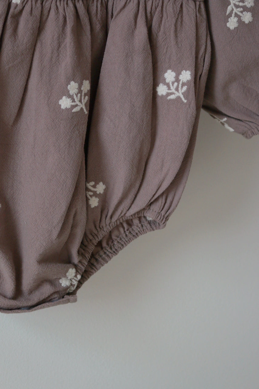 Corner Shot of grey baby bloomers with floral embroidery on a white background