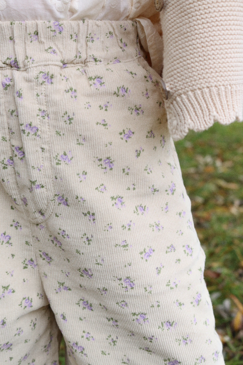 Floral-patterned pants worn by a person with a blurred natural background
