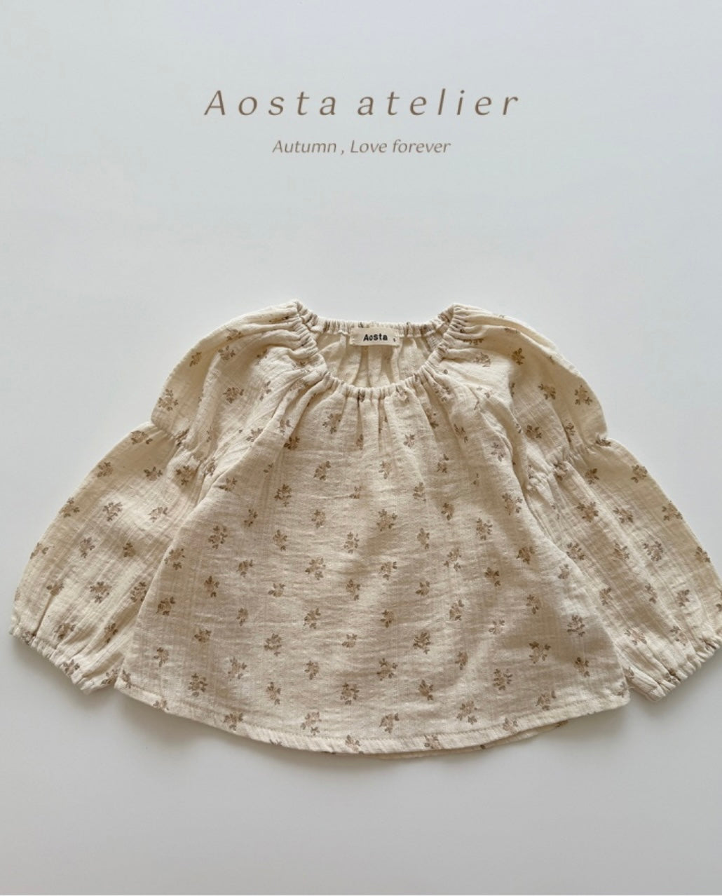 Beige floral-patterned skirt with 'Aosta atelier' branding on a light gray background