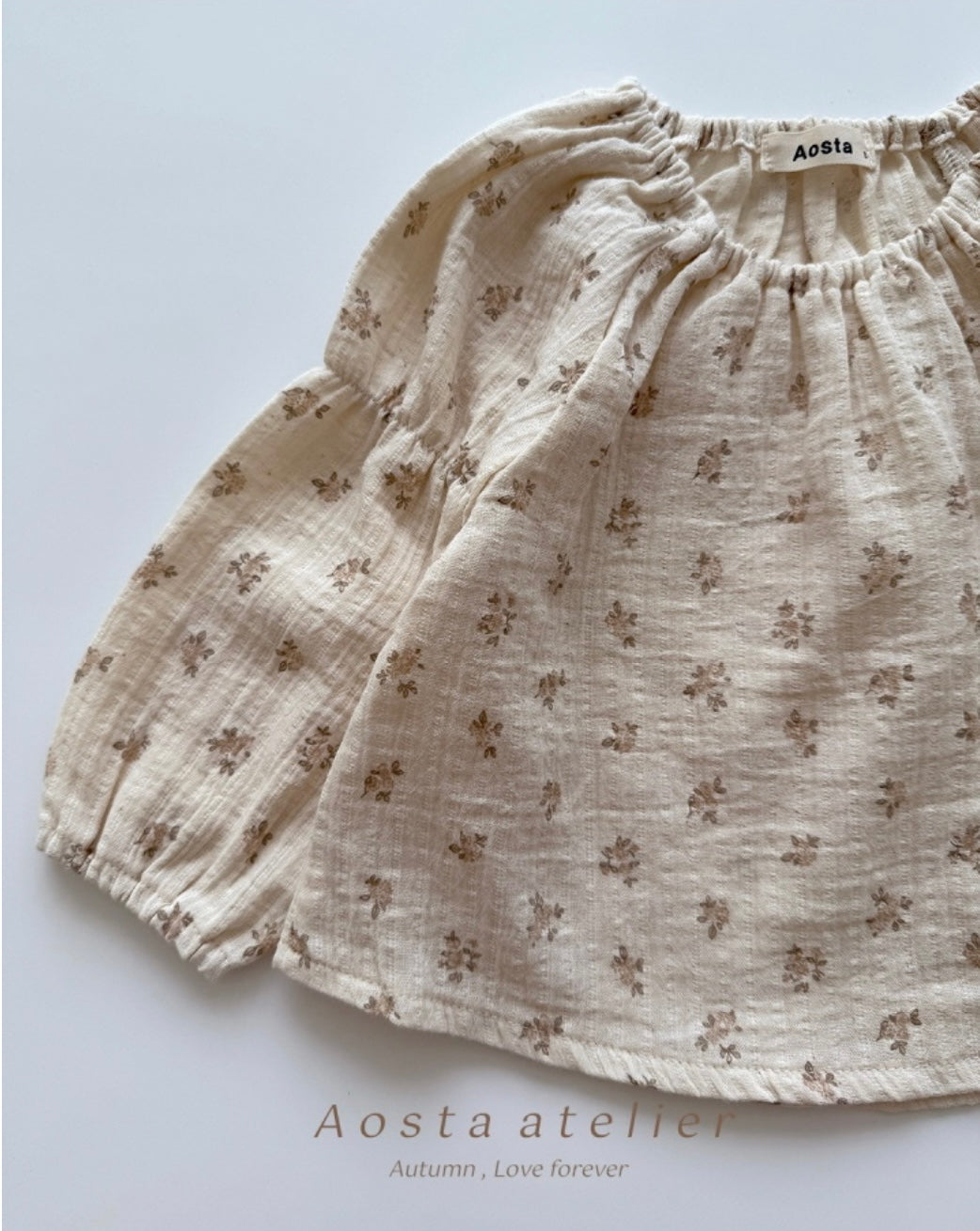 Floral patterned shorts on a light background with 'Aosta atelier' branding.