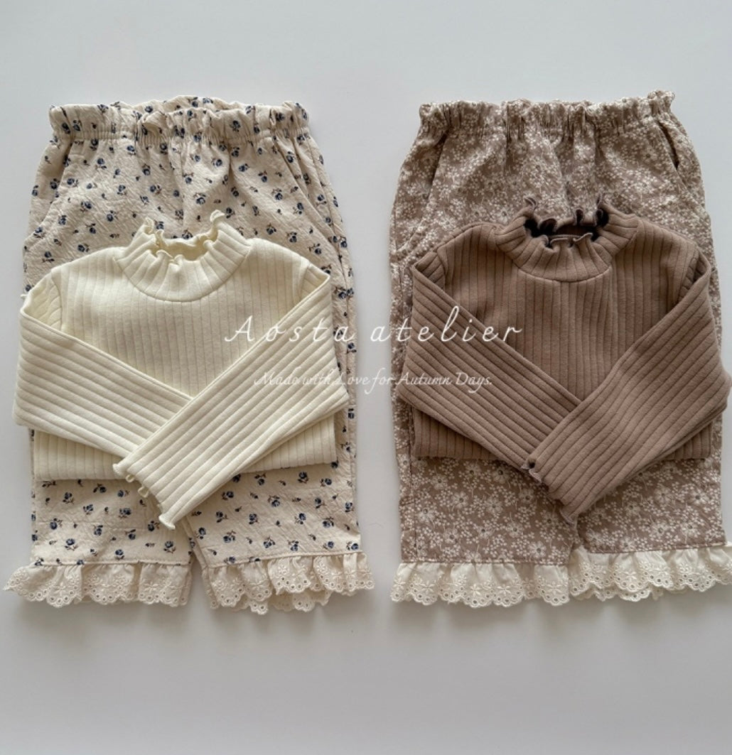 Two sets of children's clothing with floral patterns on a white background, featuring the brand 'Aosta atelier'.