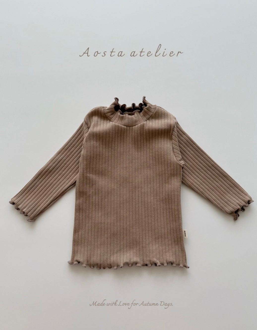 Brown ribbed top on a neutral background with 'Aosta atelier' branding.