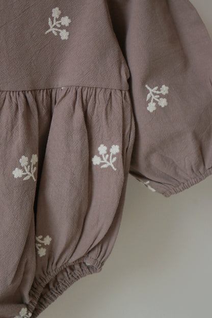 Grey children's outfit with ivory floral patterns on a neutral background