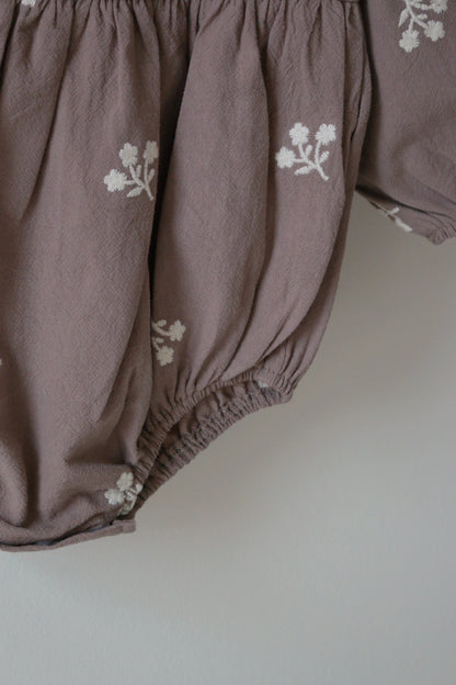 Corner Shot of grey baby bloomers with floral embroidery on a white background