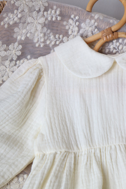 Close-up of a white muslin dress with a floral patterned surface underneath