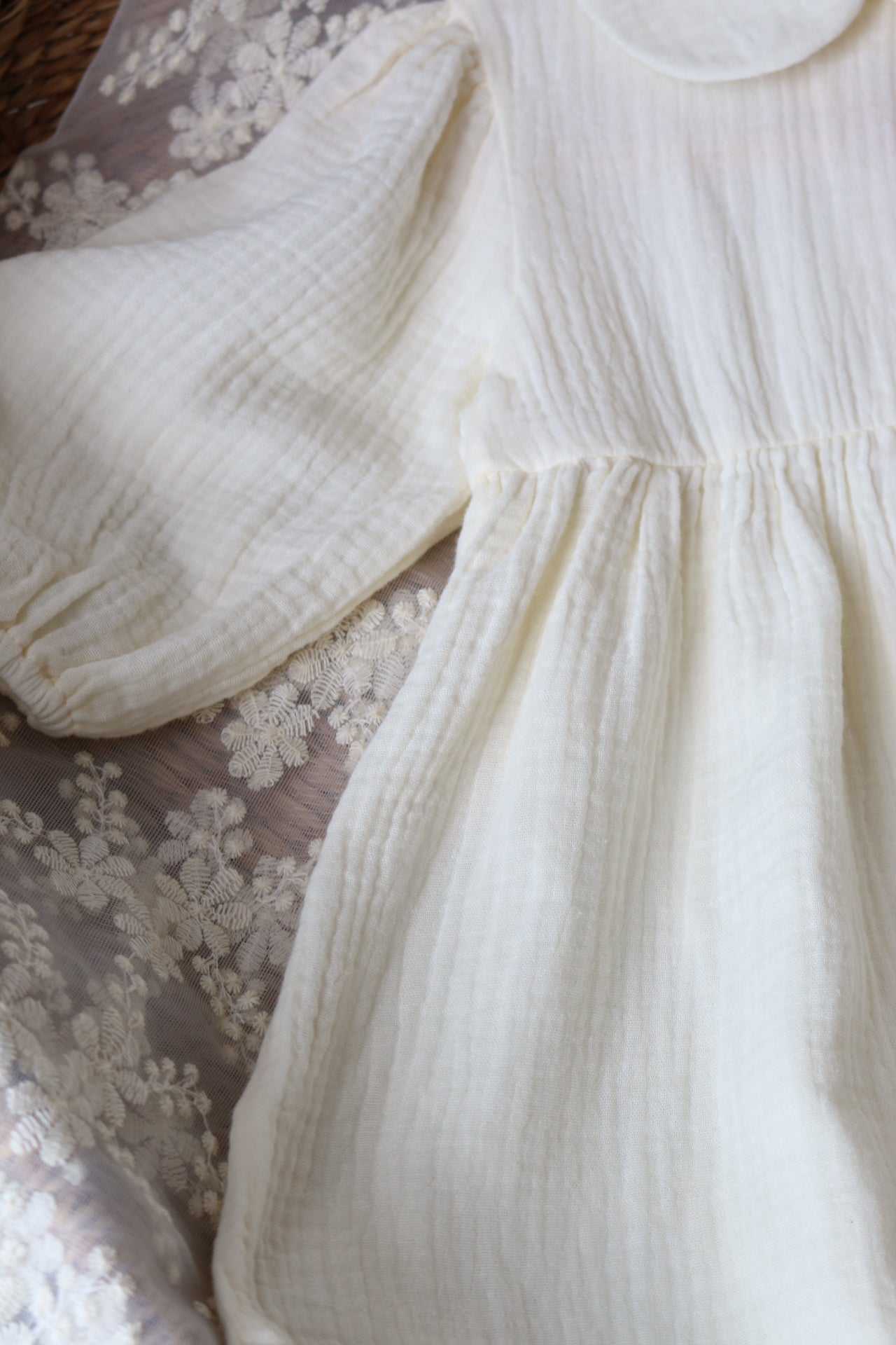 Close-up of a cream dress laid on lace detailing