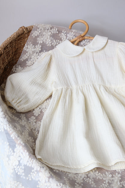 Cream dress on a floral fabric with a wicker basket