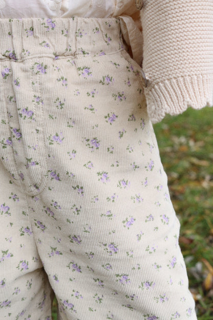Floral-patterned pants worn by a person with a blurred natural background