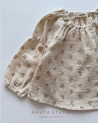 Floral patterned shorts on a light background with 'Aosta atelier' branding.