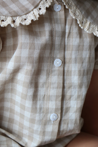 Close-up of a checkered garment with lace trim