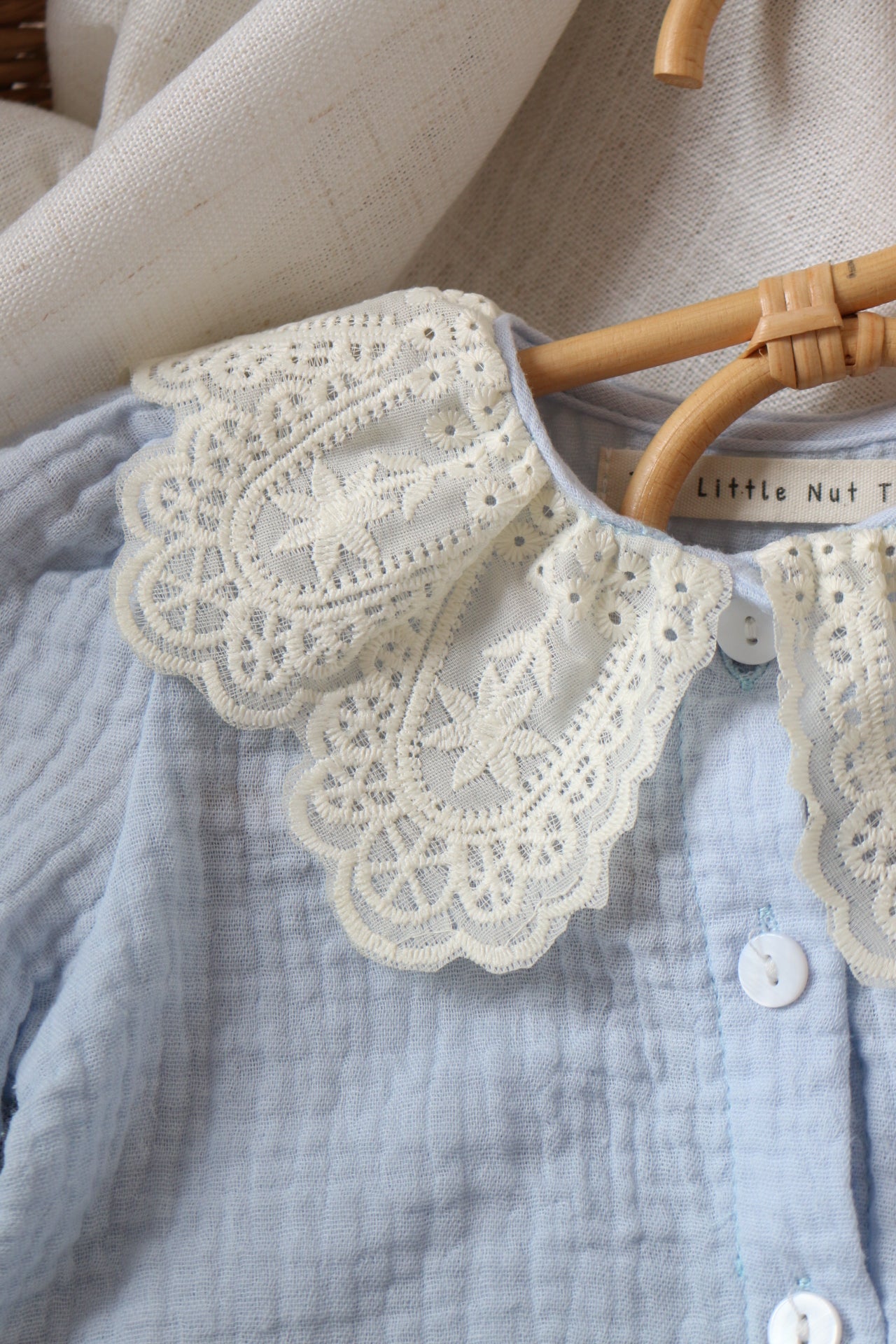 Close-up of a lace-trimmed garment on a clothing rack.